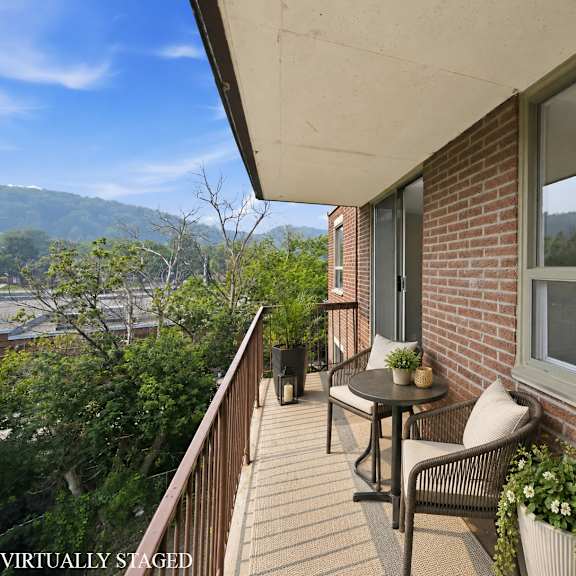 a balcony with a table and chairs overlooking a body of water.