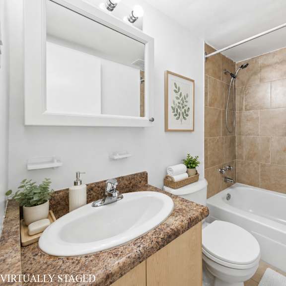 a bathroom with a sink, toilet, and bathtub.