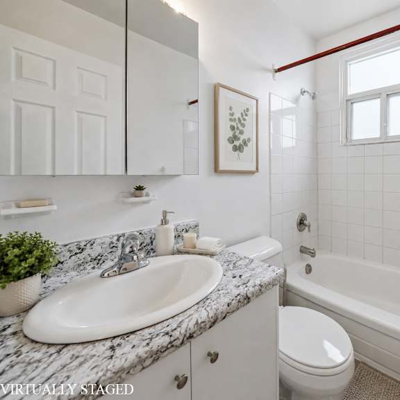 a bathroom with a marble countertop and white fixtures.