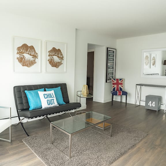 a living room with a black couch and a white chair.