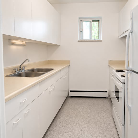 a small, clean kitchen with white appliances and cabinets.