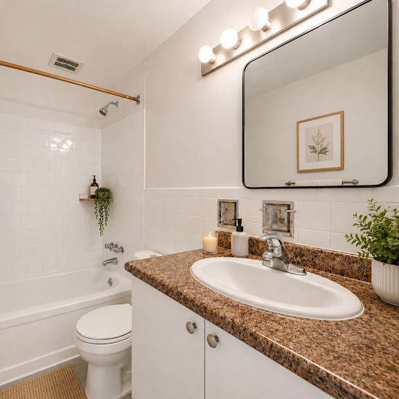 a bathroom with a brown granite countertop and a white toilet.