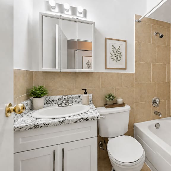 a bathroom with a white tub, toilet, and sink.