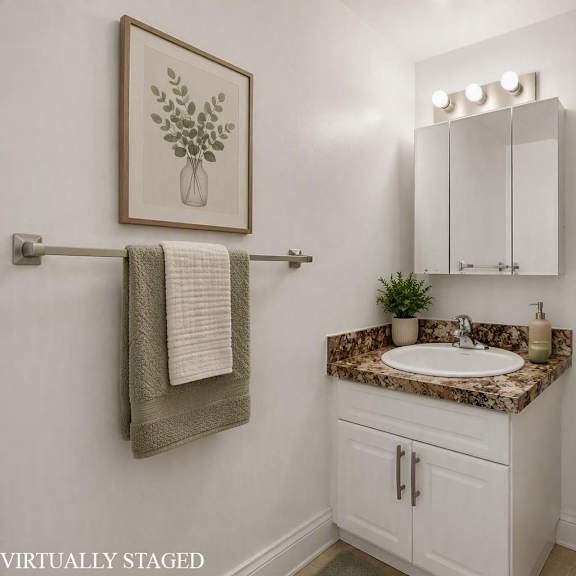 a bathroom with a toilet, sink, and a plant.
