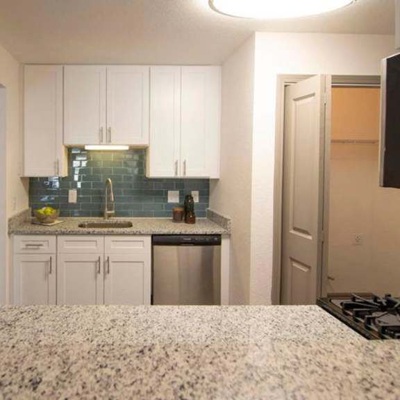 a kitchen with white cabinets and a granite countertop. at paces ridge at vinings, atlanta, georgia