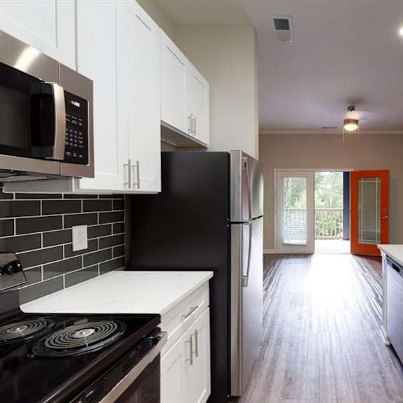 a kitchen with black and white appliances at vue at embry hills, atlanta, ga