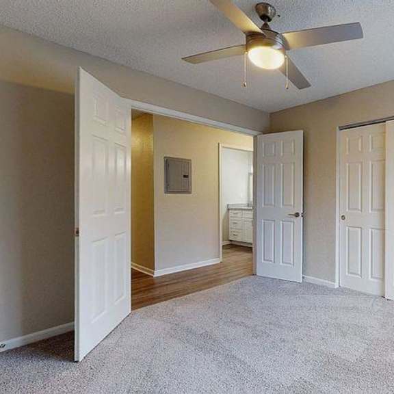 a room with a ceiling fan and carpeted floor at spalding vue, peachtree corners, ga.