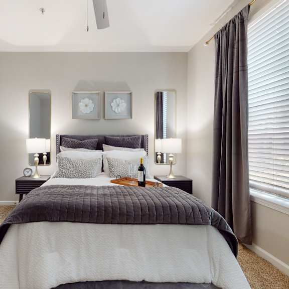 a bedroom with a bed, two lamps, and a clock on the wall at embry hills, ga, 30042