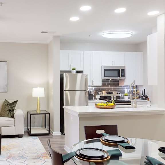 a modern kitchen and living room with a dining table set for two at embry hills, atlanta, 30042