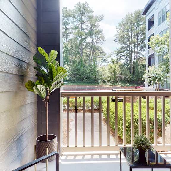 a balcony with a table and two potted plants at embry hills, atlanta, 30042