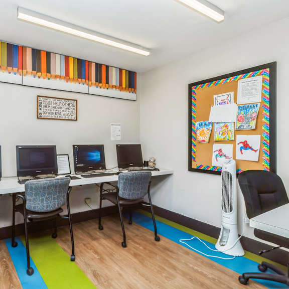 a room with a bulletin board and four computers at oak center apartments, oakland, ca, 94607