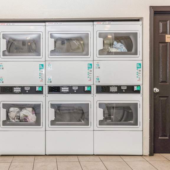 a row of white ovens with blue labels on them at oak center apartments, california, 94607