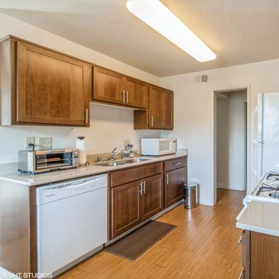 a kitchen with a white stove top oven and wooden cabinets at oak center apartments, oakland, california