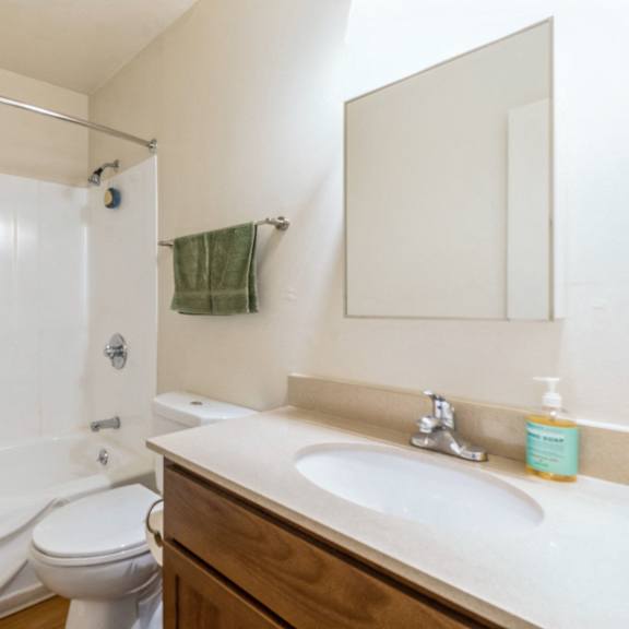 a white bathroom with a toilet, sink, and shower at oak center apartments, oakland, ca