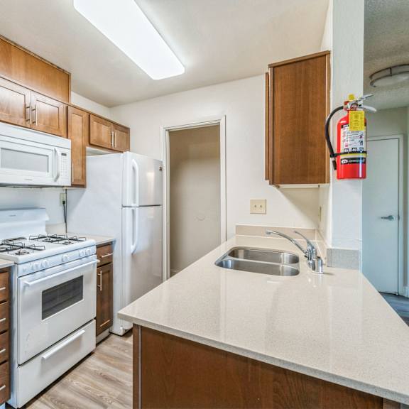 a kitchen with white appliances and wooden cabinets at oak center apartments, oakland, 94607