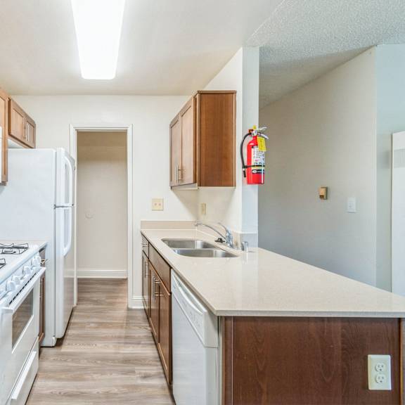 a kitchen with white appliances and wooden cabinets at oak center apartments, oakland, ca