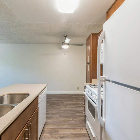a kitchen with a white refrigerator, stove, and oven at oak center apartments, oakland, ca