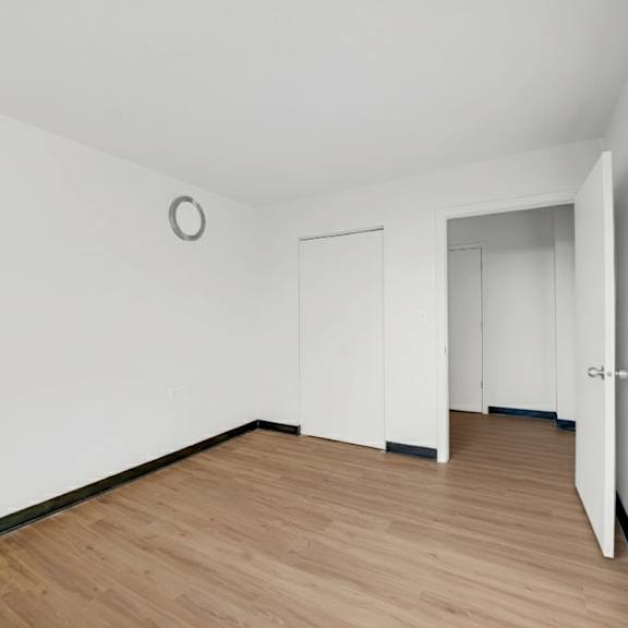 a room with a wooden floor and white walls at fullerton court apartments, chicago