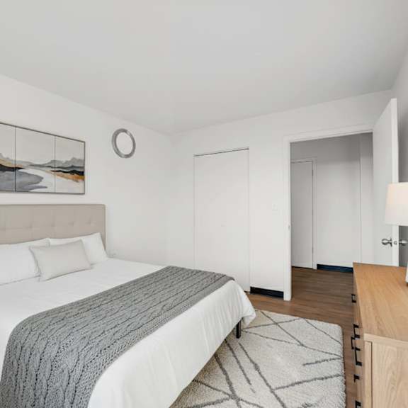 a bedroom with a large bed and a wooden nightstand at fullerton court apartments, chicago, il
