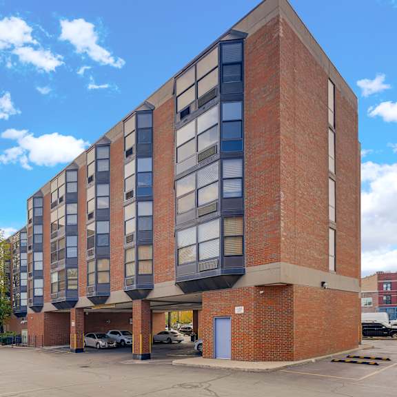 a large brick building with a parking lot in front at fullerton court apartments, illinois