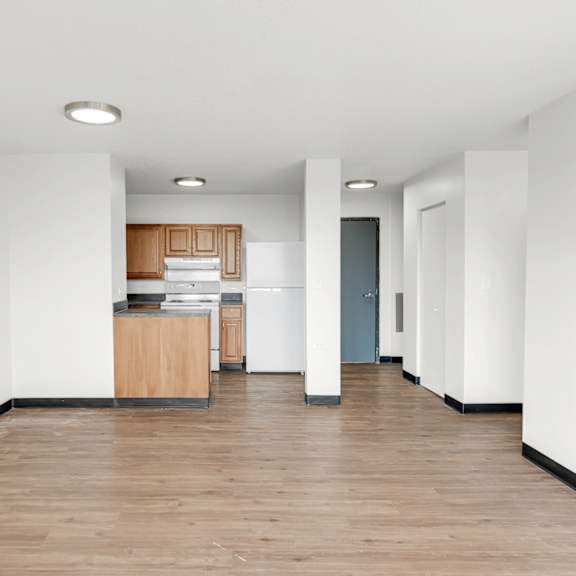 a long, empty hallway with a kitchen area at the end at fullerton court apartments, chicago, il