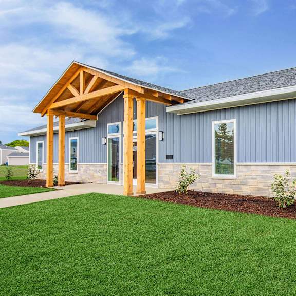 a modern house with a wooden porch and grey siding at poplar place apartments, illinois 62703