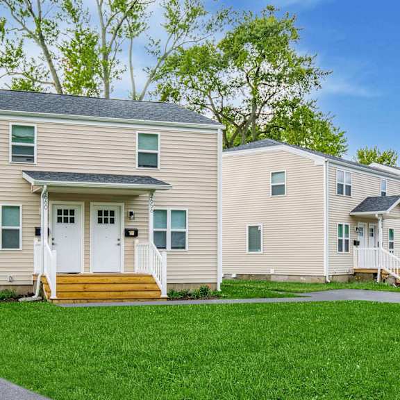 a beige house with a white door and a small porch at poplar place apartments, springfield, illinois