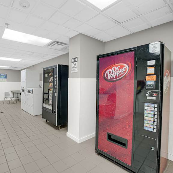pepper vending machine is in a room with a washer and dryer at fullerton court apartments, illinois 60614