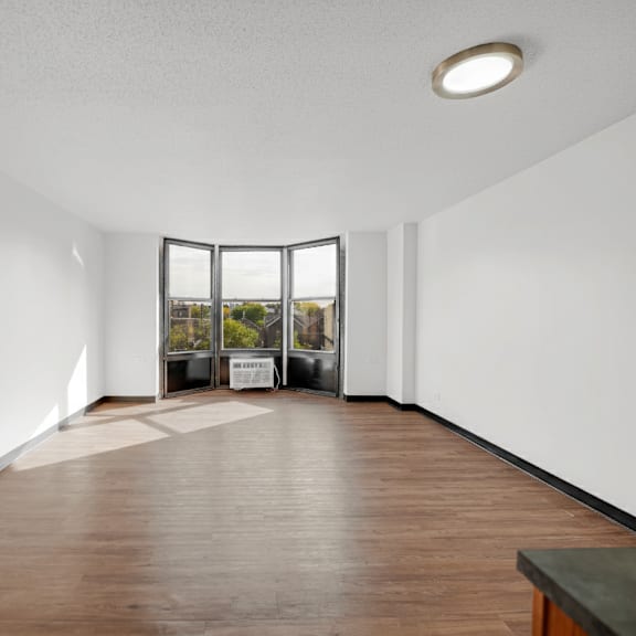 a large empty room with a wooden floor and a skylight at fullerton court apartments, chicago
