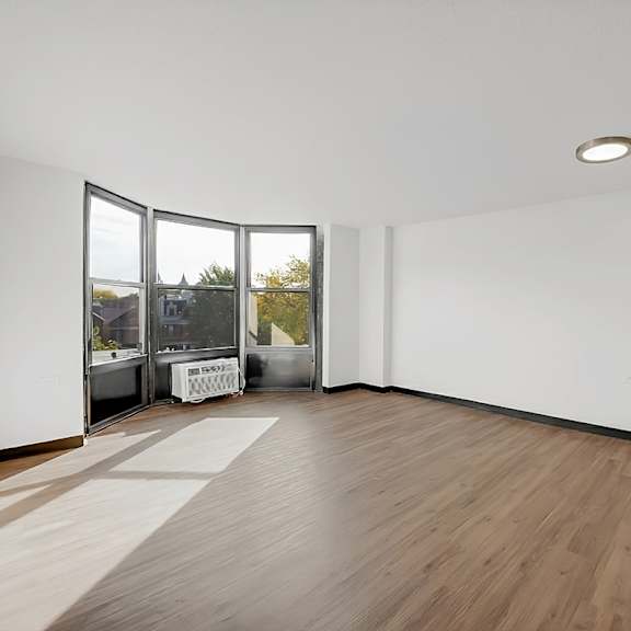 a room with a wooden floor and white walls at fullerton court apartments, chicago, illinois