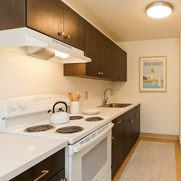 a kitchen with a white stove top and a white refrigerator at mohican apartments, connecticut, 06320