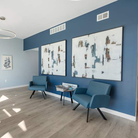 a room with blue walls and a wooden floor with two chairs and a table at poplar place apartments, springfield, il 62703
