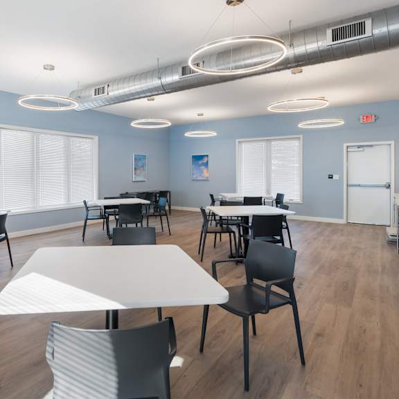 a room with tables and chairs and a painting on the wall at poplar place apartments, springfield, il