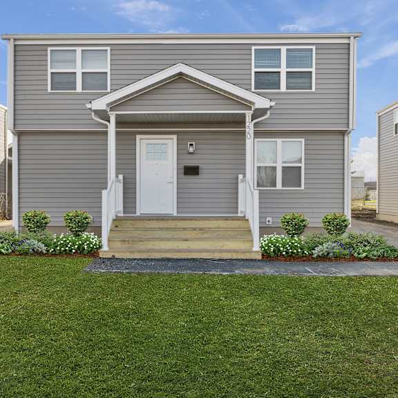 a grey house with a white door and windows at poplar place apartments, springfield, 62703