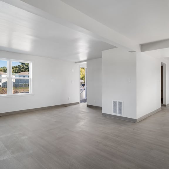 a spacious room with white walls and a wooden floor at poplar place apartments, illinois