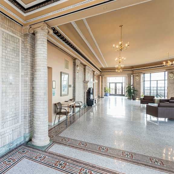 a large, open lobby with a marble floor and a chandelier hanging from the ceiling at mohican apartments, connecticut, 06320