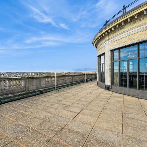 a balcony with a railing and a building with a glass facade at mohican apartments, new london, 06320