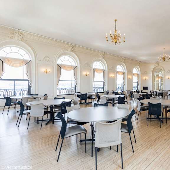 a large room with tables and chairs and a chandelier at mohican apartments, connecticut