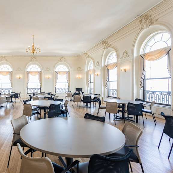 a large room with tables and chairs and a balcony with a railing at mohican apartments, new london, ct, 06320