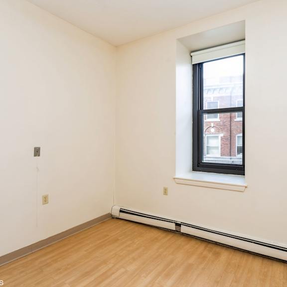 a room with a window and a wooden floor at mohican apartments, new london, ct