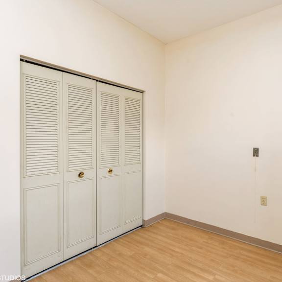 closed white doors with brass knobs in a room with wooden floor and white walls at mohican apartments, connecticut, 06320