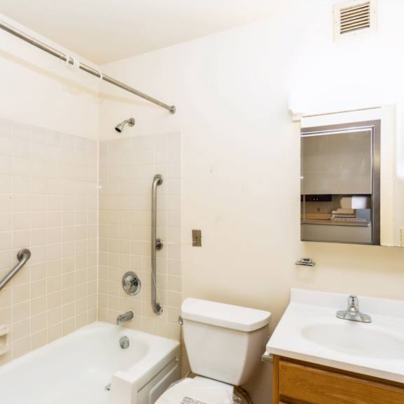 a white bathroom with a toilet, sink, and bathtub at mohican apartments, new london, connecticut