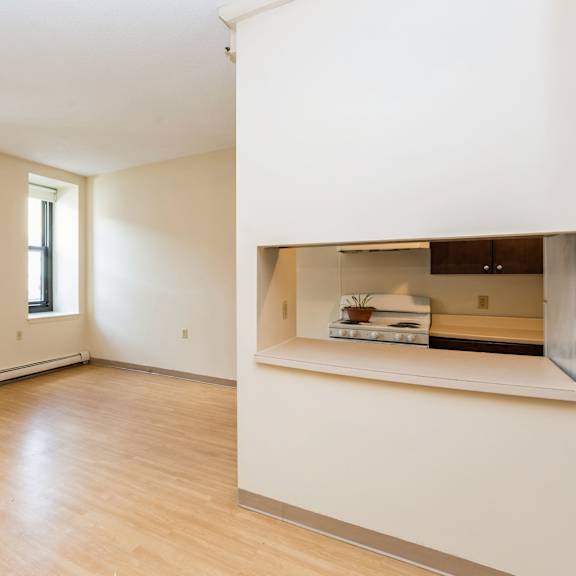 a large empty room with wooden floors and white walls at mohican apartments, connecticut