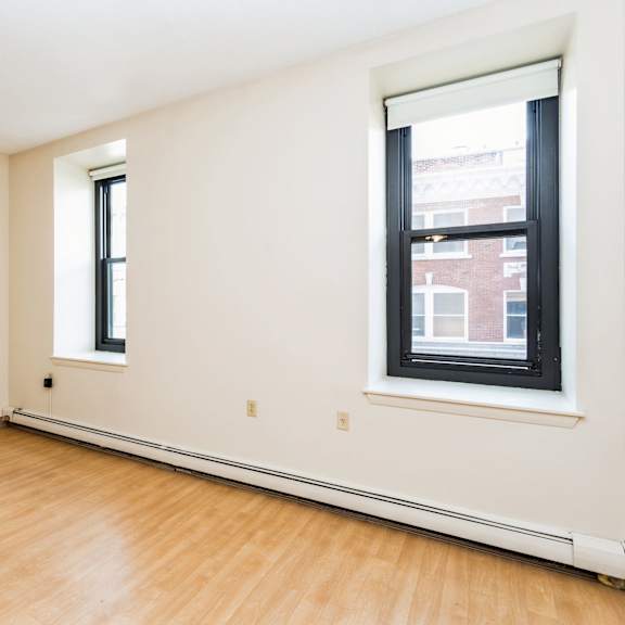 empty room with a window and wooden floor at mohican apartments, new london