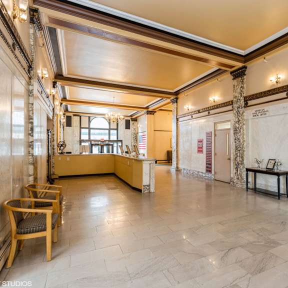 a spacious room with a wooden floor and a large window at mohican apartments, new london
