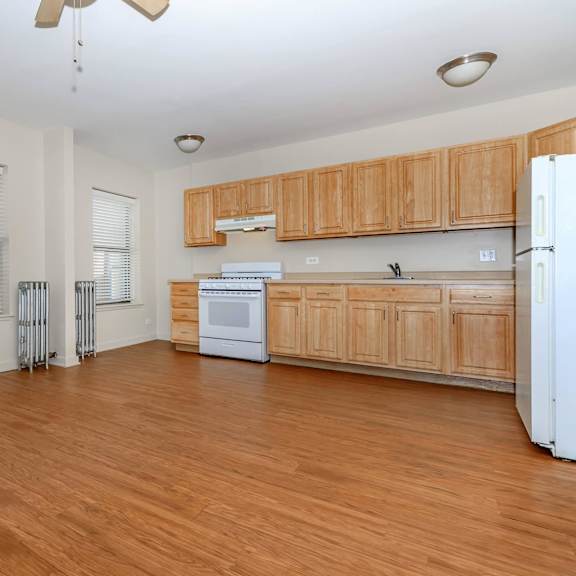 a kitchen with wooden cabinets and a white refrigerator at sheridan park, chicago, il 60640