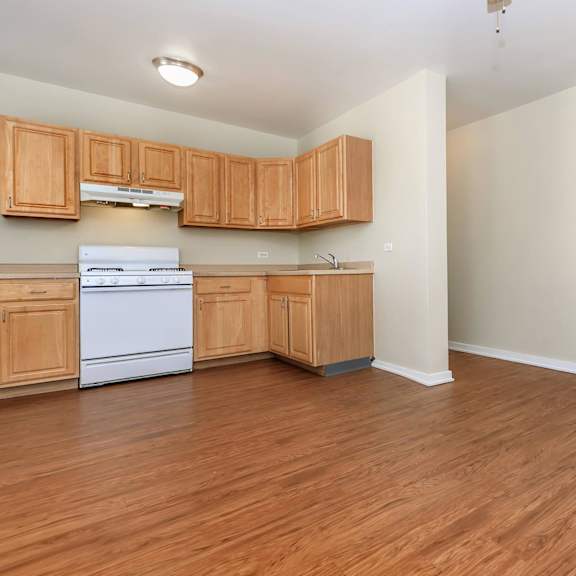 a kitchen with wooden cabinets and a white dishwasher at sheridan park, chicago, 60640