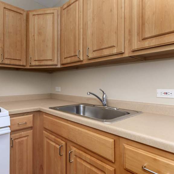 a white gas stove is in a kitchen with wooden cabinets at sheridan park, chicago, il