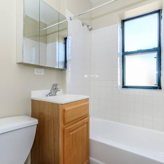 a white toilet sits next to a sink in a bathroom at sheridan park, chicago, illinois