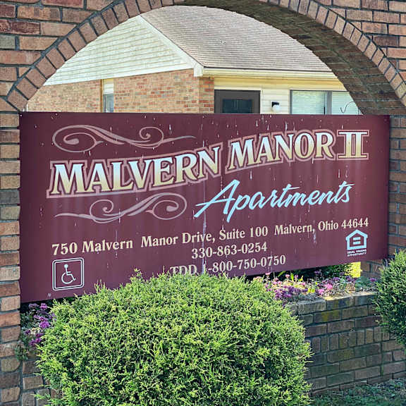 a sign for malvern manor ii apartments is displayed on a brick wall.